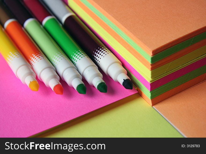 Colorful pencils over colored peaces of paper. Colorful pencils over colored peaces of paper