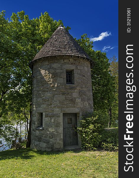 A old water mill in the forest on a blue sky