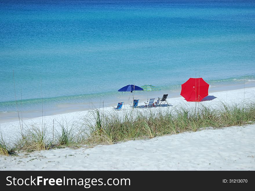 Relaxing under beach umbrellas on the sand with beach chairs overlooking the ocean. Relaxing under beach umbrellas on the sand with beach chairs overlooking the ocean.
