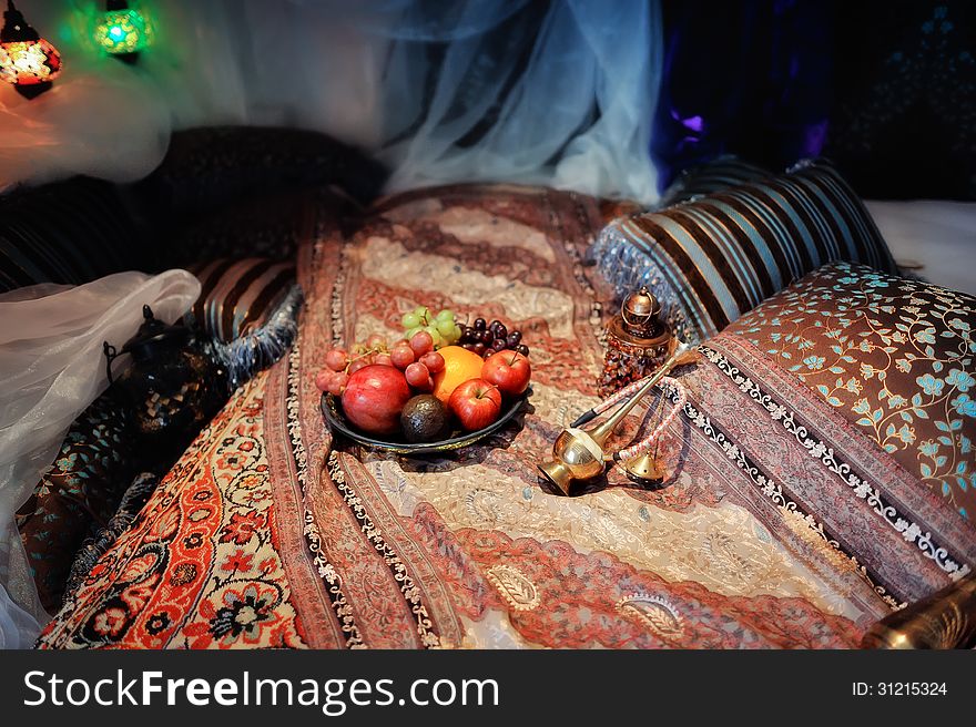 Still life in the Oriental style, on the carpets, fruit plate and a hookah. Still life in the Oriental style, on the carpets, fruit plate and a hookah