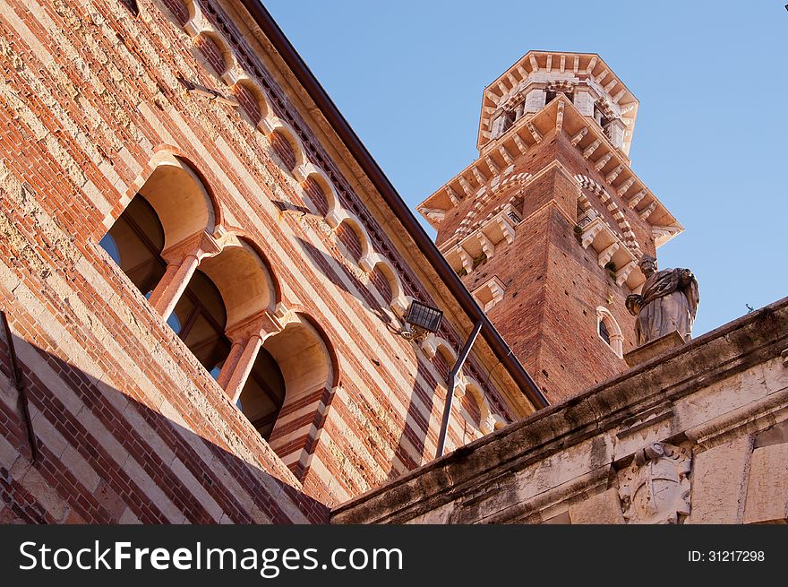 Verona, Italy - September 14 2012: Lamberti Tower, the tallest clock tower in the center of the ancient city of Verona. The tower was begun in 1172; in May 1403 a lightning struck it, but only in 1448 restoration works were started, lasting until 1464. Verona, Italy - September 14 2012: Lamberti Tower, the tallest clock tower in the center of the ancient city of Verona. The tower was begun in 1172; in May 1403 a lightning struck it, but only in 1448 restoration works were started, lasting until 1464.