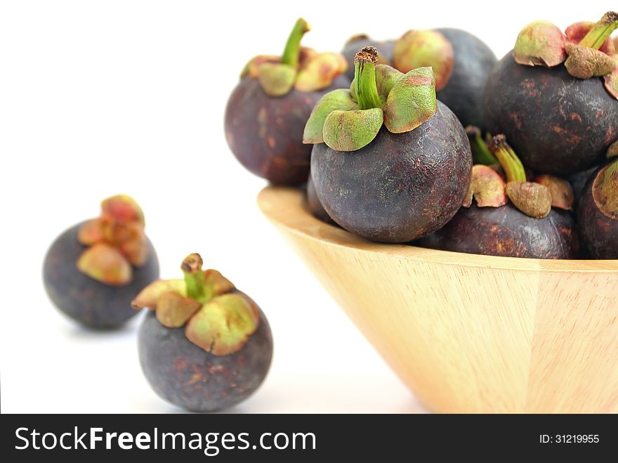 Mangosteen in a wooden bowl on white background