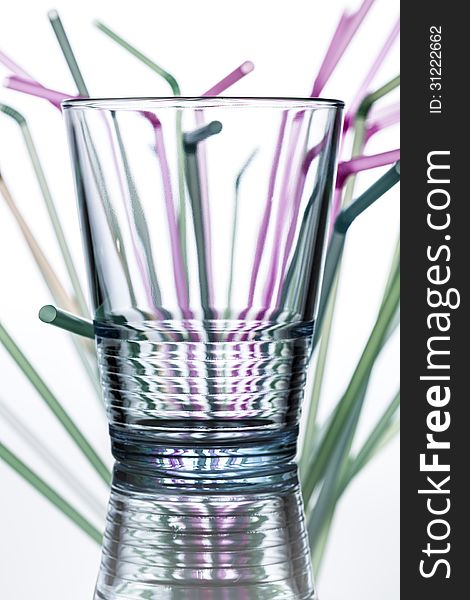 Water glass with straws in the background