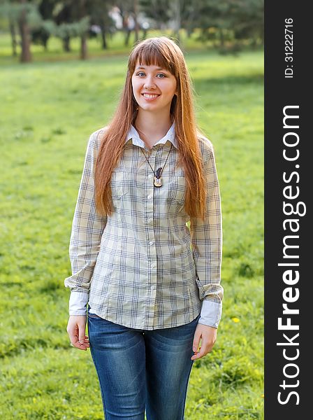 The girl poses on a green background of city park. 2013. The girl poses on a green background of city park. 2013