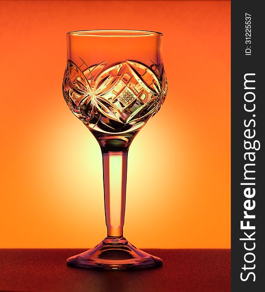 Small liqueur glass standing at the orange gradiend background
