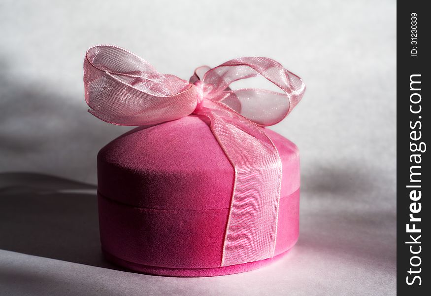 Elegant pink gift box with a bow on the table