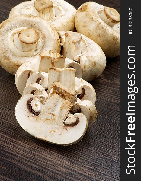 Heap of Big White Champignons Full Body and Slices on Dark Wood background. Heap of Big White Champignons Full Body and Slices on Dark Wood background