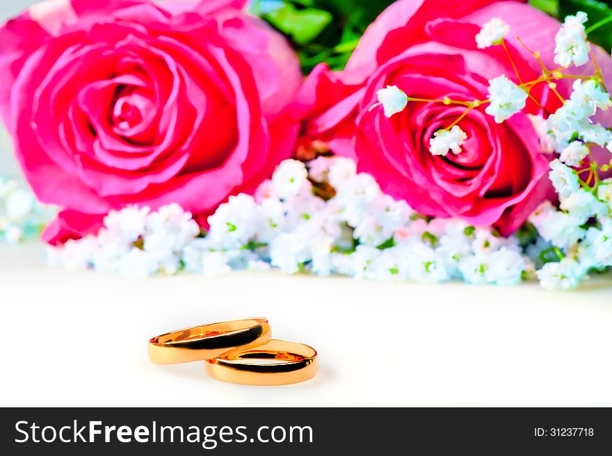 Wedding rings with rose on a white background