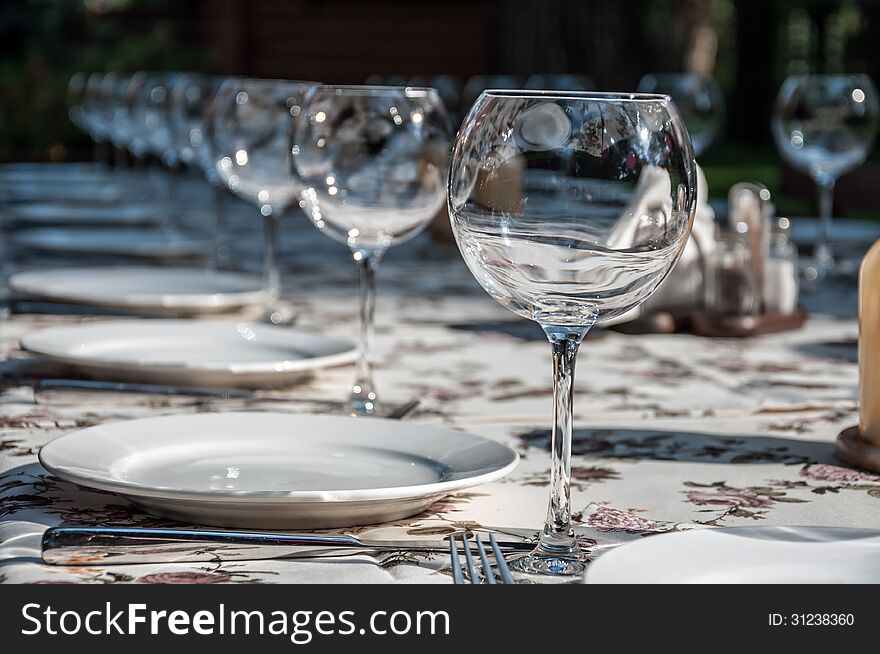 Empty footed tumblers,glasses and party plates on festive served table. Empty footed tumblers,glasses and party plates on festive served table