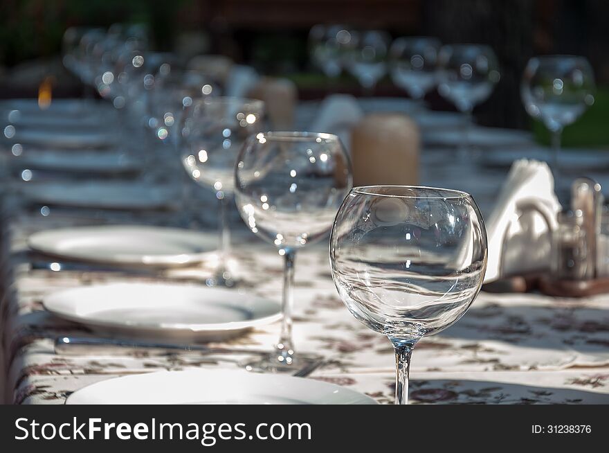 Empty footed tumblers,glasses and party plates on festive served table. Empty footed tumblers,glasses and party plates on festive served table