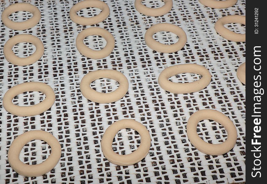 Round-shaped bagels are moving on a conveyor belt in the furnace department. Round-shaped bagels are moving on a conveyor belt in the furnace department