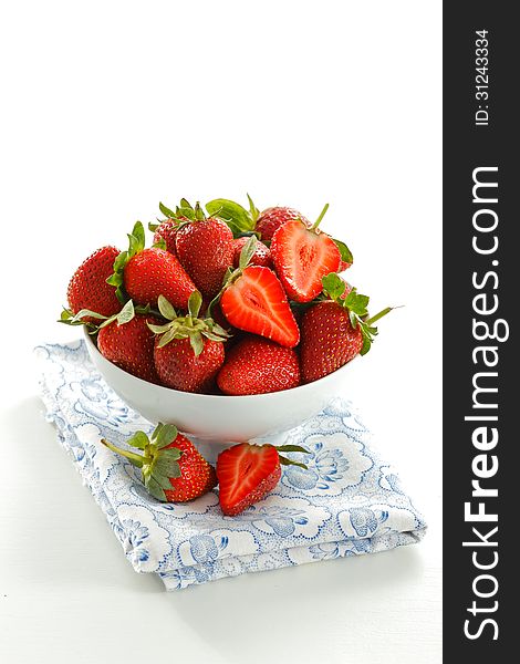 White bowl with fresh strawberries on blue napkin. White bowl with fresh strawberries on blue napkin