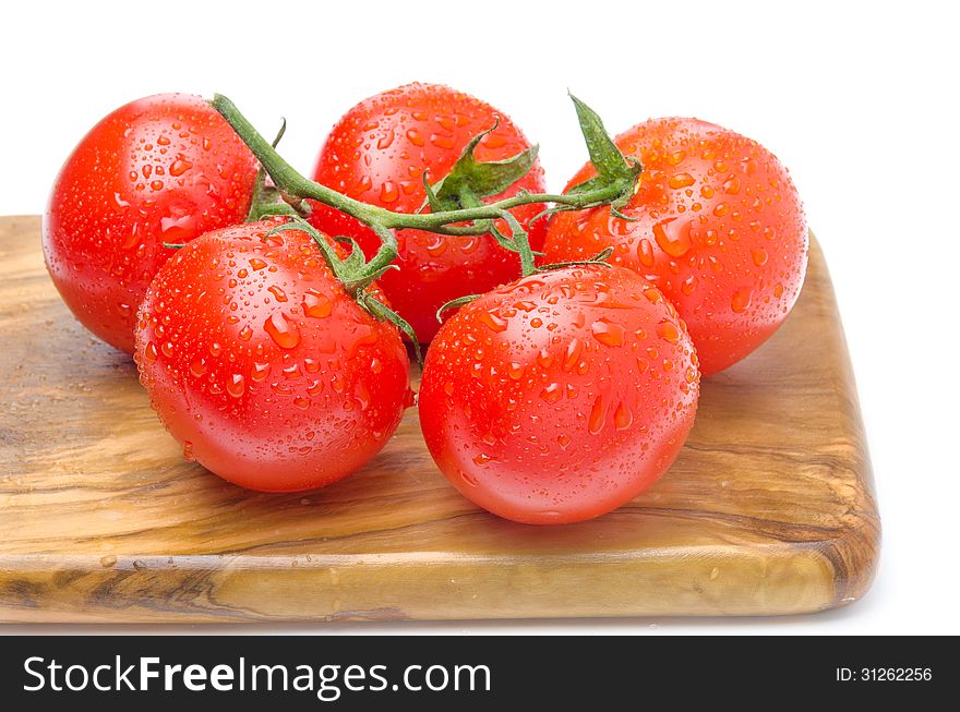 Fresh Tomatoes On A Branch On A Wooden Board Isolated