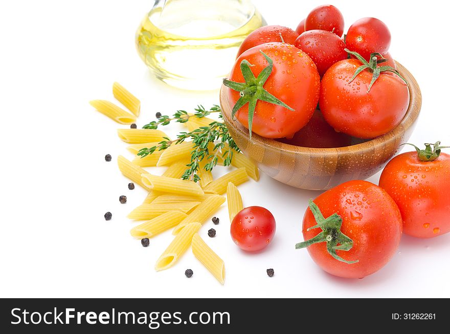 Fresh tomatoes, pasta penne, olive oil and spices isolated on a white background. Fresh tomatoes, pasta penne, olive oil and spices isolated on a white background