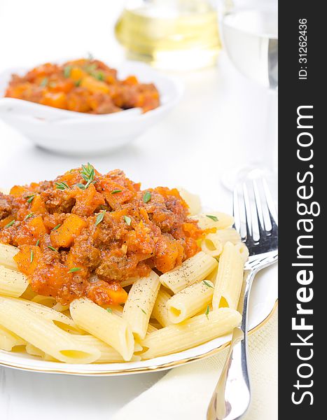 Penne pasta with sauce of beef, tomato and pumpkin close-up