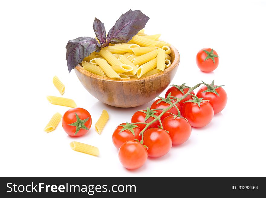 Penne pasta, fresh tomatoes and basil isolated on a white background