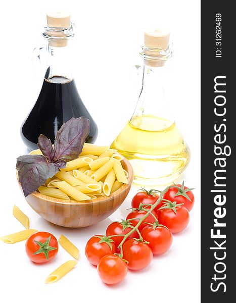 Penne pasta, fresh tomatoes, basil, olive oil and balsamic vinegar isolated on white background