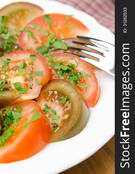 Salad of two varieties of tomatoes with fresh parsley close-up