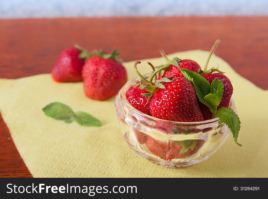 Delicious, juicy, red strawberries lying on the table in the saucer with mint. Delicious, juicy, red strawberries lying on the table in the saucer with mint