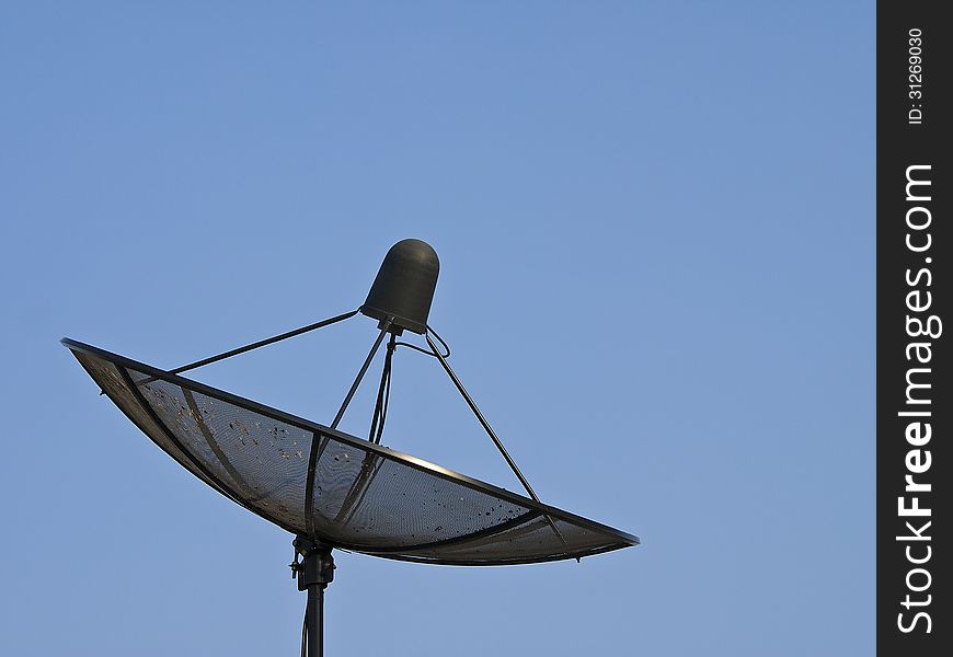 Black satellite dish in blue sky and sunlight. Black satellite dish in blue sky and sunlight
