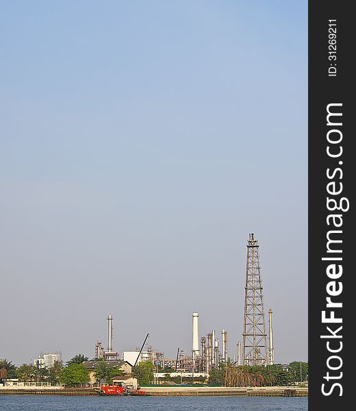 Tower of oil refinery along side of river