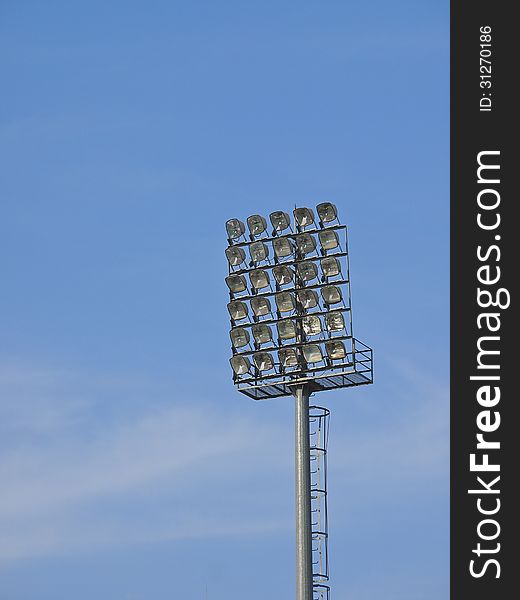 High pole and stadium floodlight in cloudy sky. High pole and stadium floodlight in cloudy sky