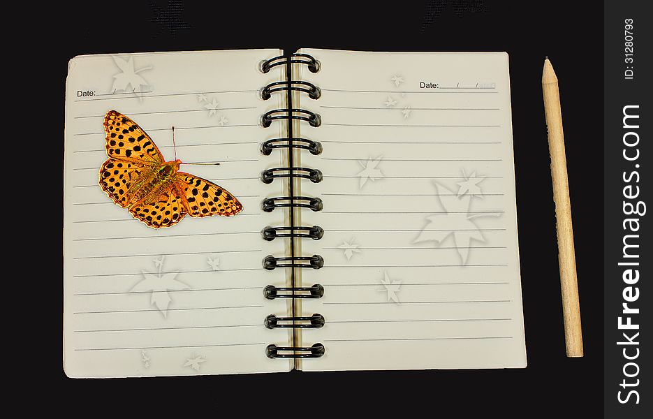 Notebook and pencil and butterfly on black color background.