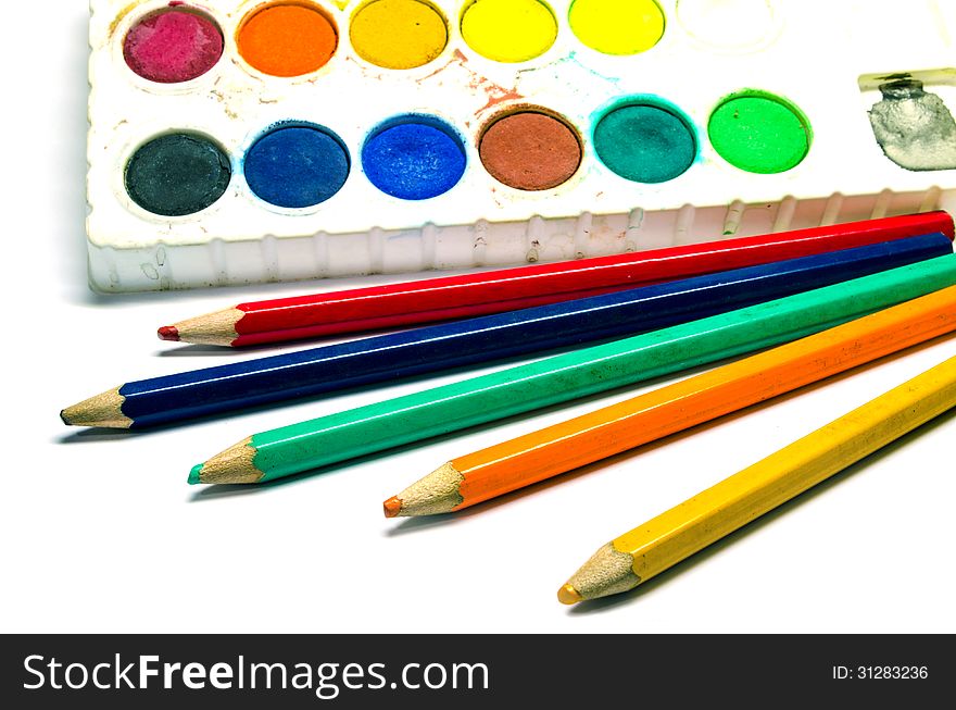 A dirty water color palette and color pencils isolated on white background