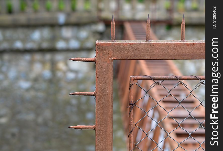 Rusty fence protected with dangerous metallic system