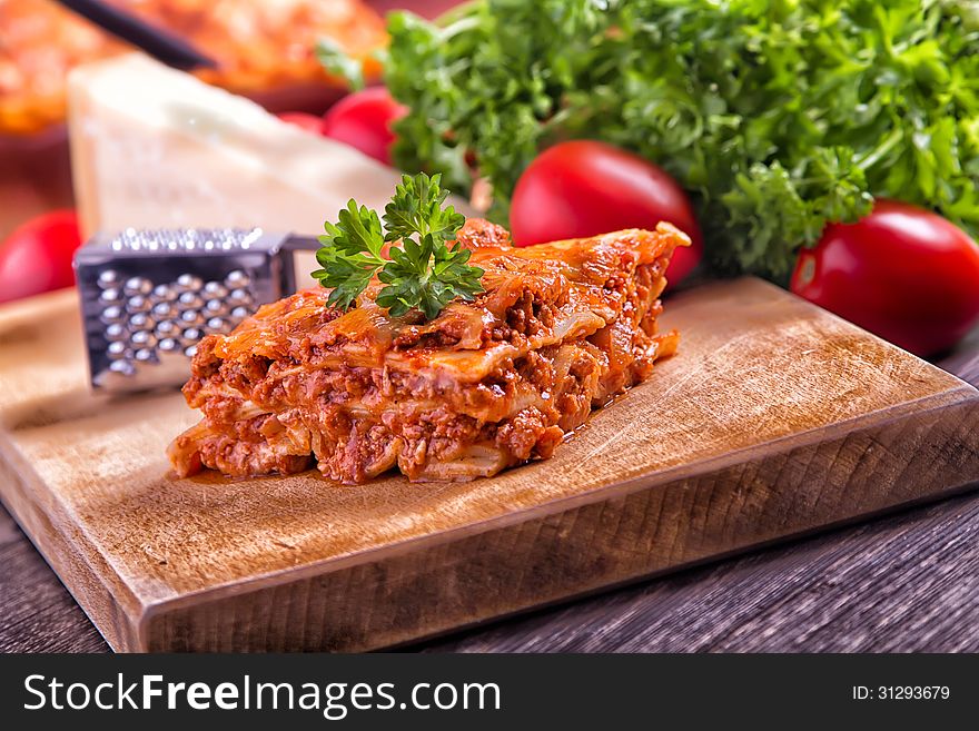 Closeup lasagna on a wooden board. Closeup lasagna on a wooden board