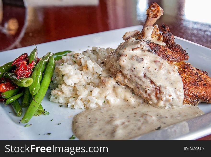 This is airline chicken...that has the bone cooked in with the chicken with a risotto and green beans. This is airline chicken...that has the bone cooked in with the chicken with a risotto and green beans.