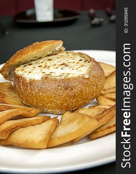 This is an artichoke cheese dip with a bread bowl with toast points. This is an appetizer at a high end restaurant