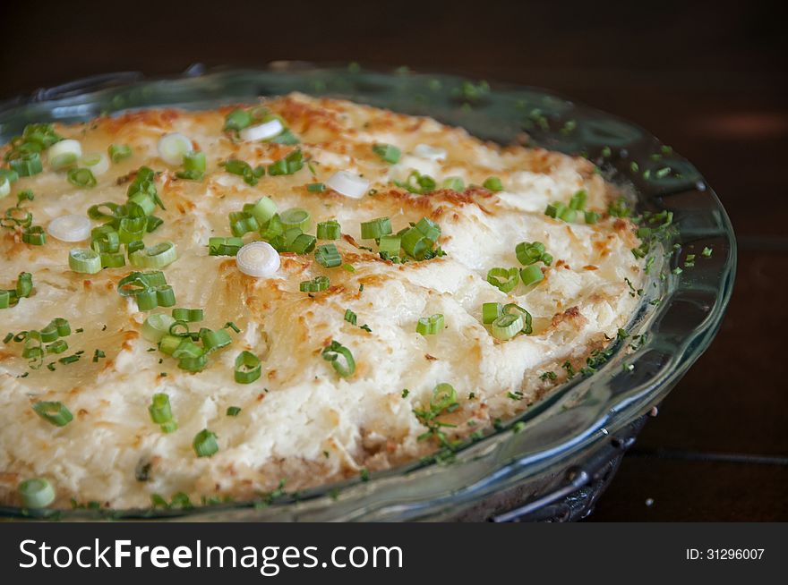 This is a shepherds pie, a beef filling that is covered with a mashed potato then baked and garnished with green onion