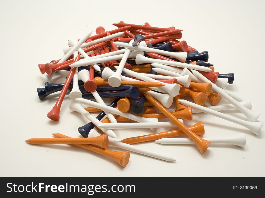 Pile of multi-colored golf tees on white background. Pile of multi-colored golf tees on white background