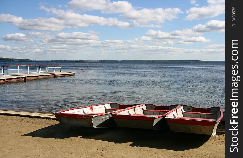 Boats on coast of a sandy beach.