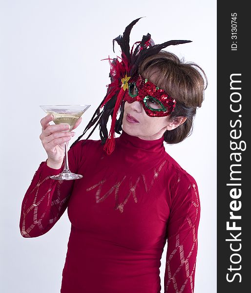 A woman in a festive sequined mask holding a martini glass as if at a party. A woman in a festive sequined mask holding a martini glass as if at a party.