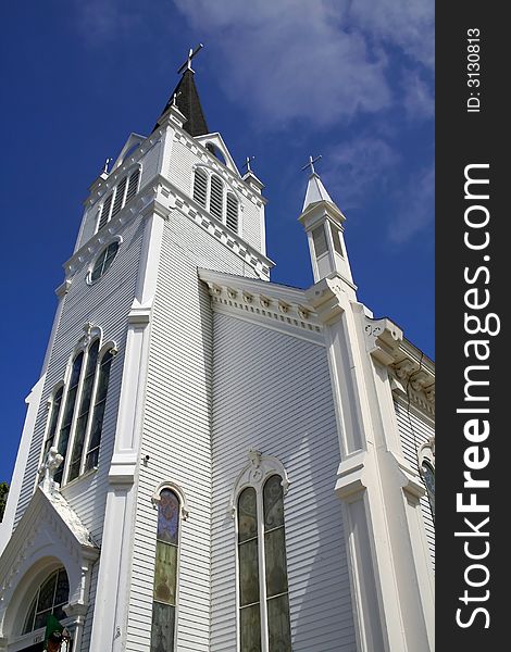 Wide angle shot of white church with blue sky background. Wide angle shot of white church with blue sky background