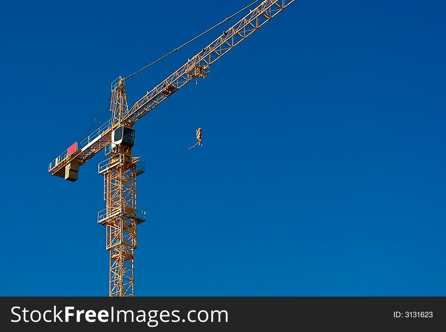 A heavy construction crane against a clear blue sky