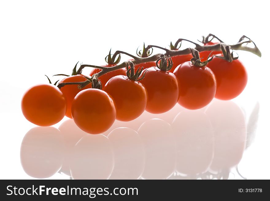 Red cherry tomatoes on a branch, white background