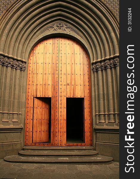 Wood, golden, entrance gates to San Juan cathedral in Arucas, Great Canary island, built in neogothic style last century. Wood, golden, entrance gates to San Juan cathedral in Arucas, Great Canary island, built in neogothic style last century