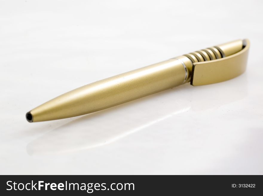 Golden plastic pen on white background.