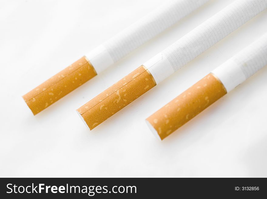 Three cigarets in line on white background.
