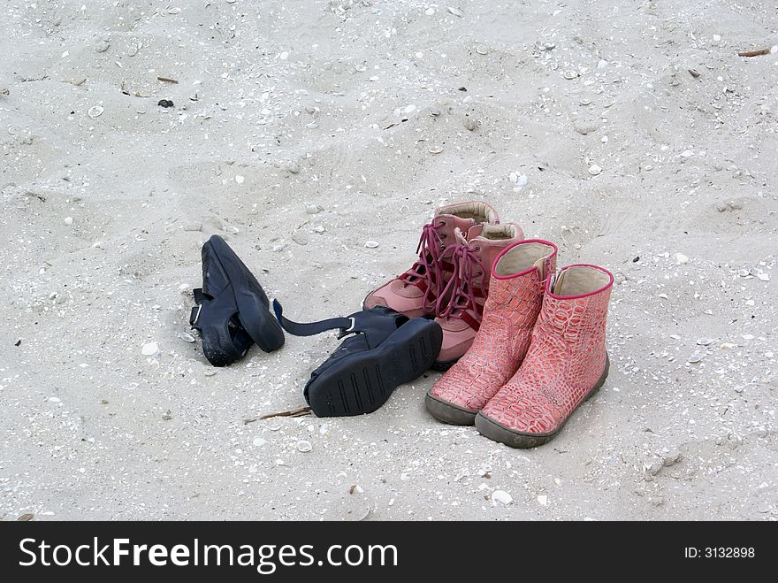 Three pairs of shoes on the beach. Three pairs of shoes on the beach.