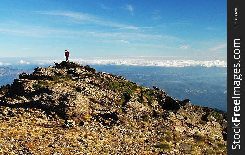 A man admiring a view from a peak in the Pyrenees. A man admiring a view from a peak in the Pyrenees