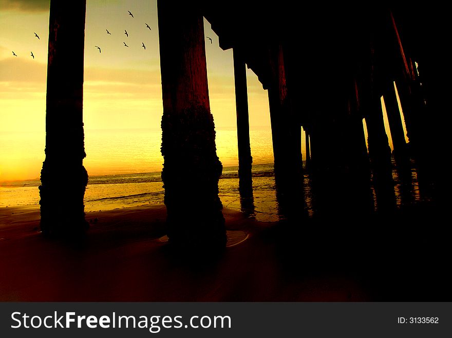 Sunset seen through the unside of a pier. Sunset seen through the unside of a pier.