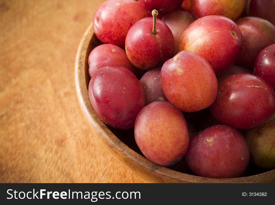 Fresh plums in a wooden bowl
