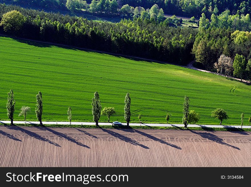 Spring landscpe with bright-green field and road. Spring landscpe with bright-green field and road.