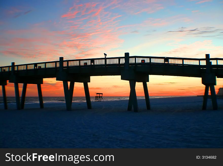 Sunset at the beach with pier and life guard stand. Sunset at the beach with pier and life guard stand