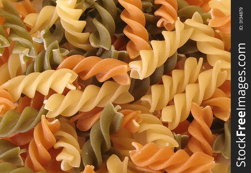 Orange, green and yellow pasta for a background. Orange, green and yellow pasta for a background