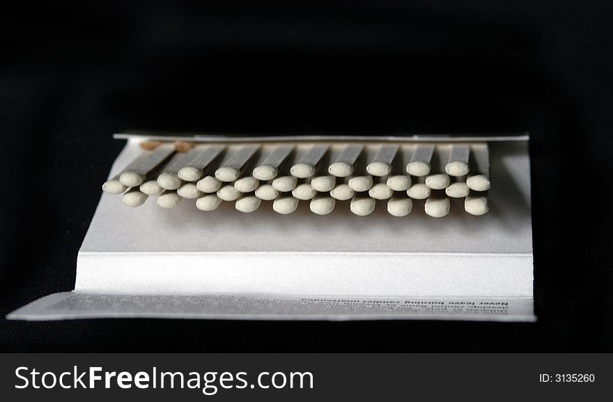 A book of white matches isolated on a black background. A book of white matches isolated on a black background.